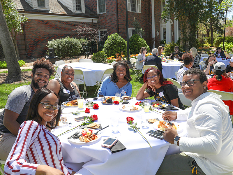 Students seated outdoors at the Unity Meal