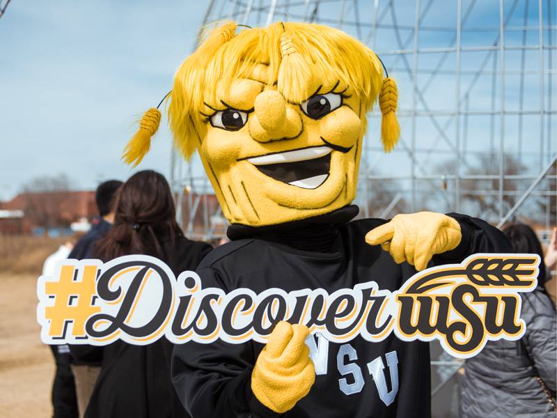 Wu holding up a #DiscoverWSU sign