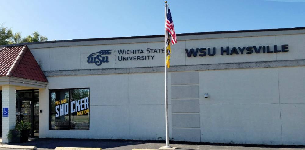 Two WSU Old Town students smiling as they leave the building on a bright, sunny day. 