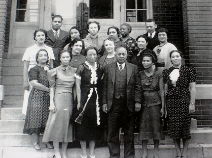 The 'Separate is Not Equal' exhibit documents segregation in Wichita's public schools. This image shows the faculty and staff of L'Ouverture School in 1938.