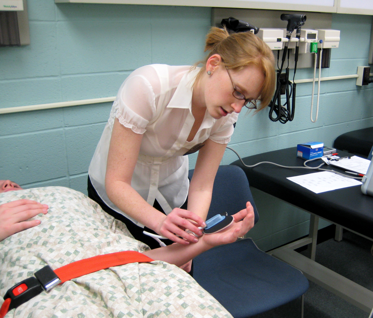 Graduate PA student Erin Gurss checks her volunteer - graduate PA student Kyrie Webster - as part of a collaborative study for WSU, Wesley Medical Center and the KU School of Medicine-Wichita.
