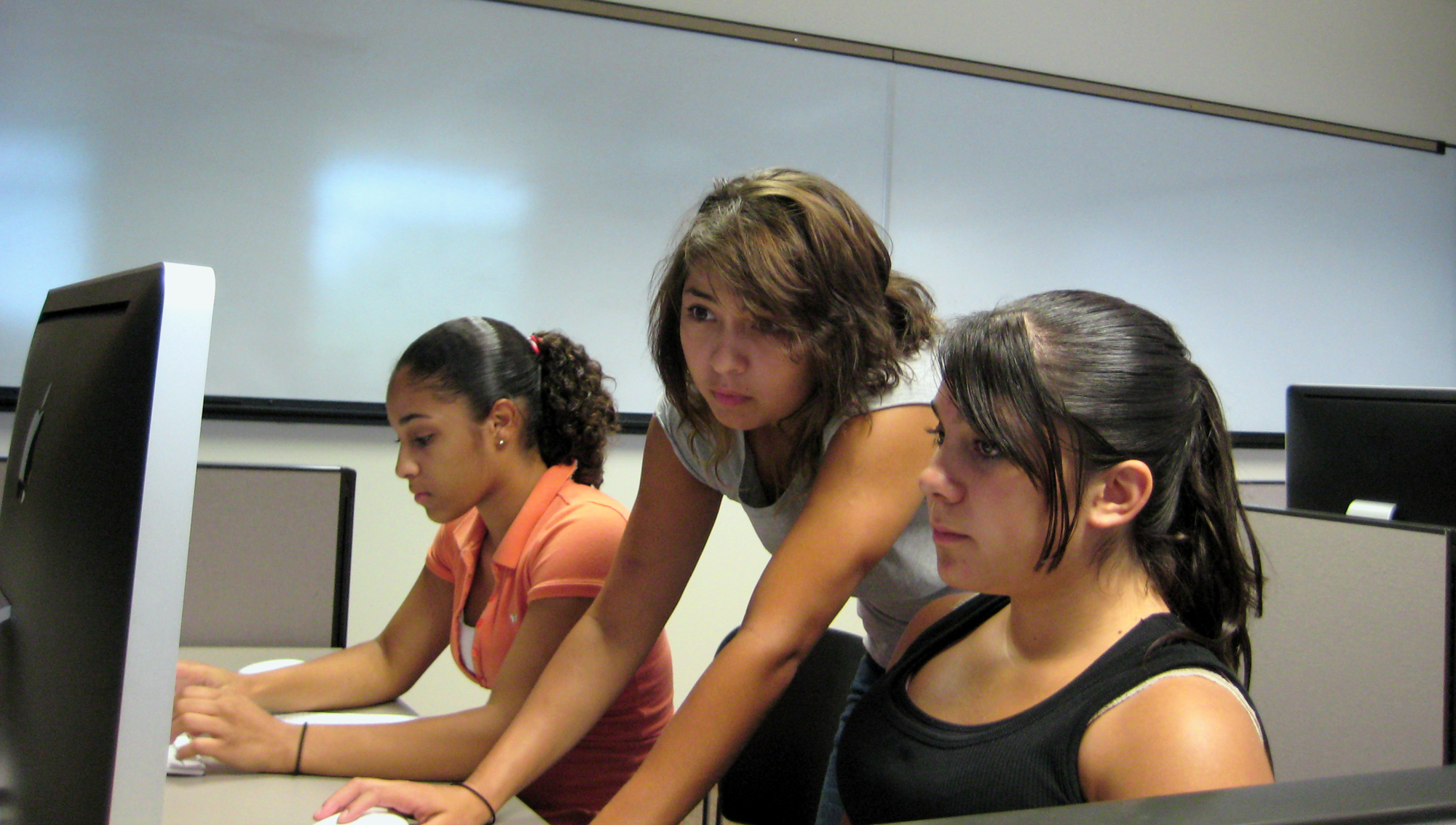 Roni Ayalla, the camp's Web production instructor, assists two students in producing an online news source to showcase the campers' work.