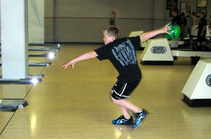 A camper participating in the Youth Day bowling camp practices his technique.