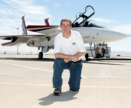 Wichita State University student Jordan Jensen kneels in front of an F-15 at Edwards Air Force Base in Edwards, Calif. NASA's Dryden Flight Research Center, where Jensen interns, is located on the base.