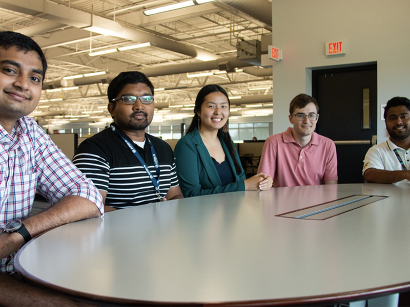 From left to right: Alok Dand, Suveen Emmanuel, Angelique Banh, Shane Grode and Pardhiv Marella sit at a table in the Airbus Wichita facility