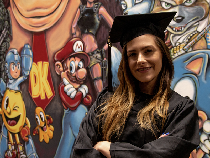 Michaela Marioni poses in front of a Nintendo character mural in Shocker Studios