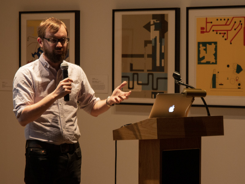 Brian Amos, assistant professor of political science, gives a Feb. 19 talk on gerrymandering at the Ulrich Museum of Art