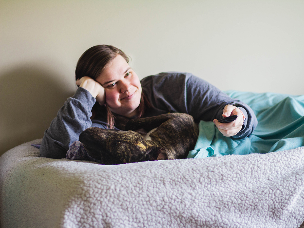 A girl cuddling with her dog.