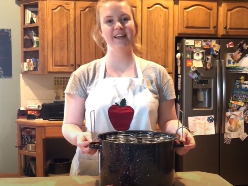 Wichita State student demonstrates canning techniques in a kitchen.