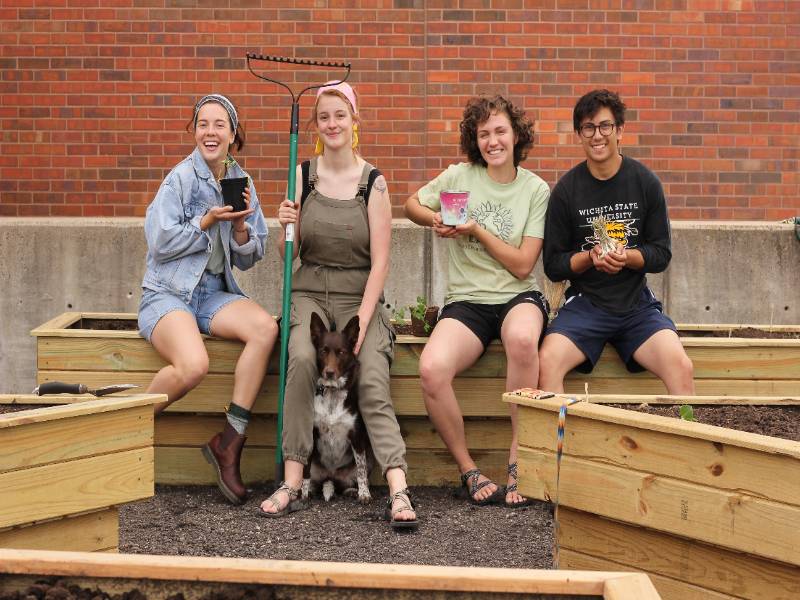 From left to right: Morgan Cusick, Quinn Rhodes, Maya (the garden mascot), Madi Laughlin and Ryne Carballo working in the garden before social distancing measures we put in place.