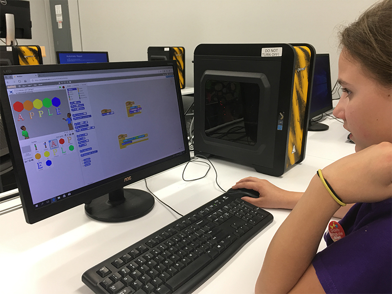 A Girl Scout does an activity on a computer. 