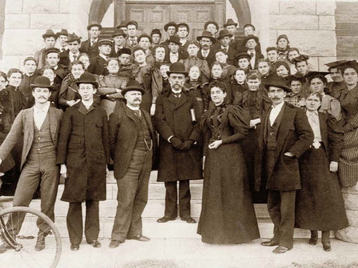 Nathan Morrison, first Fairmount College president, stands at center, surrounded by his students and faculty on the steps of Fairmount Hall.