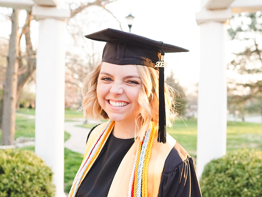 Student wearing a graduation cap and smiling