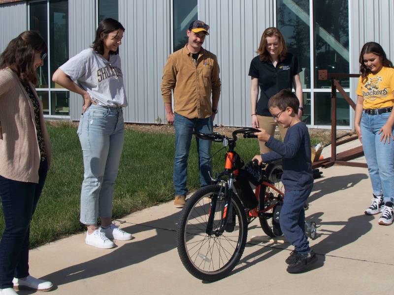 Wichita State University engineering students present Ford Hall with a bicycle they modified to meet his needs.
