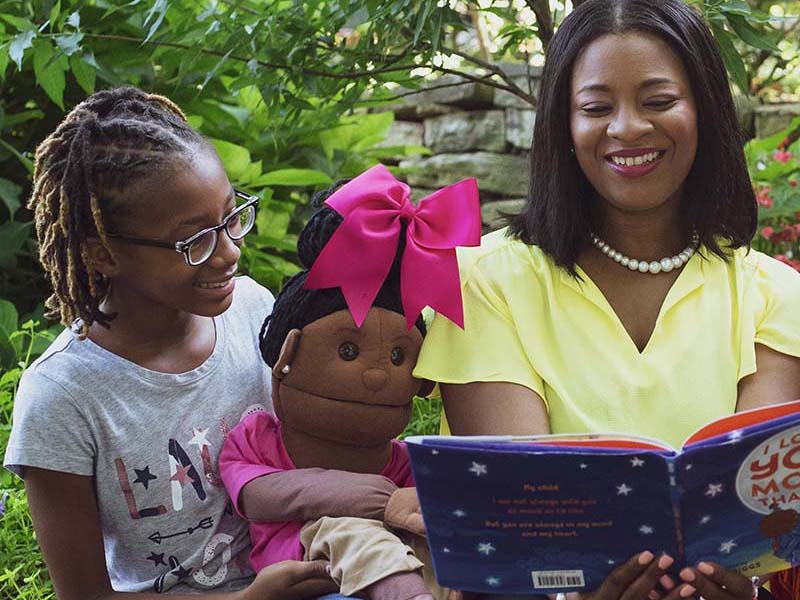 Prisca Barnes (right) reads to a student at Storytime Village. 