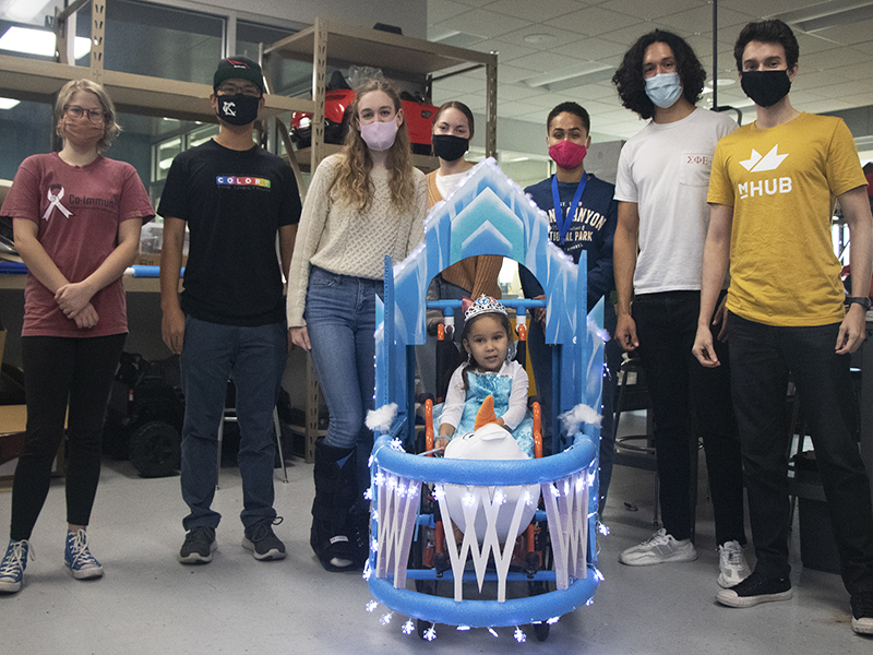 Wichita State students pose with Alyssa in her Elsa costume made as part of the Walkin' & Rollin' program.