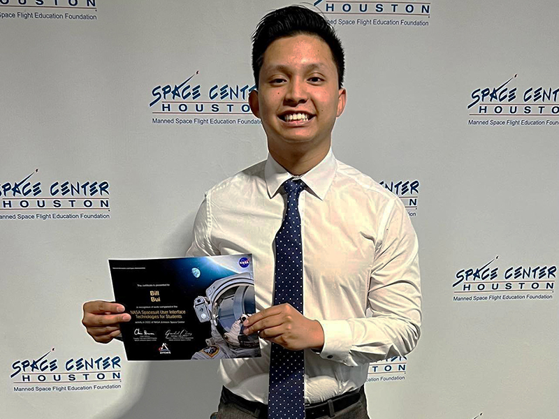 Image of Bill Bui holding up award at Space Center Houston.