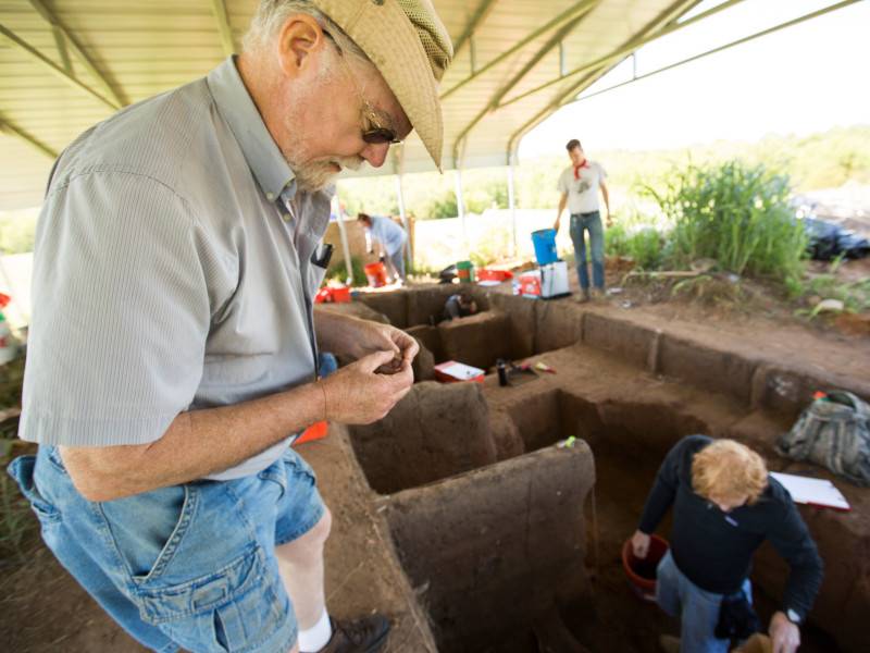 Blakeslee inspects an artifact while on-site in Etzanoa.