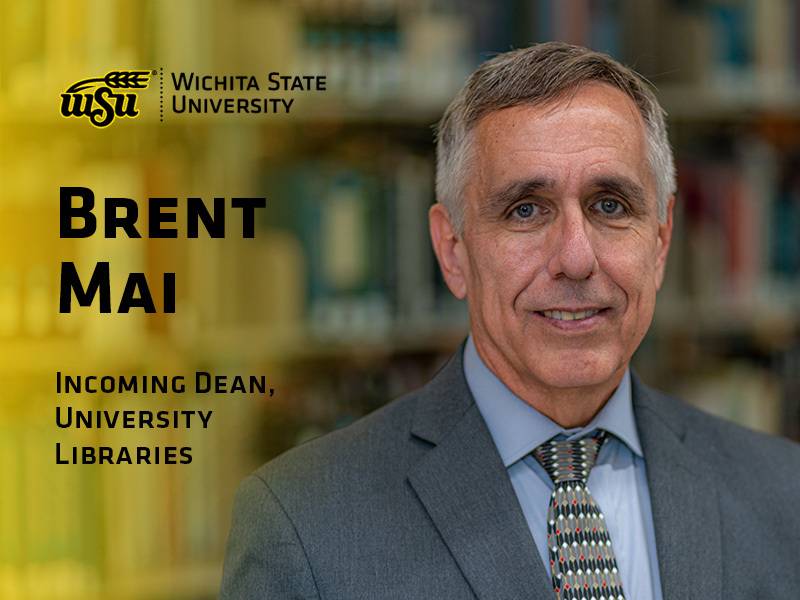 Brent Mai stands in front of a bookcase