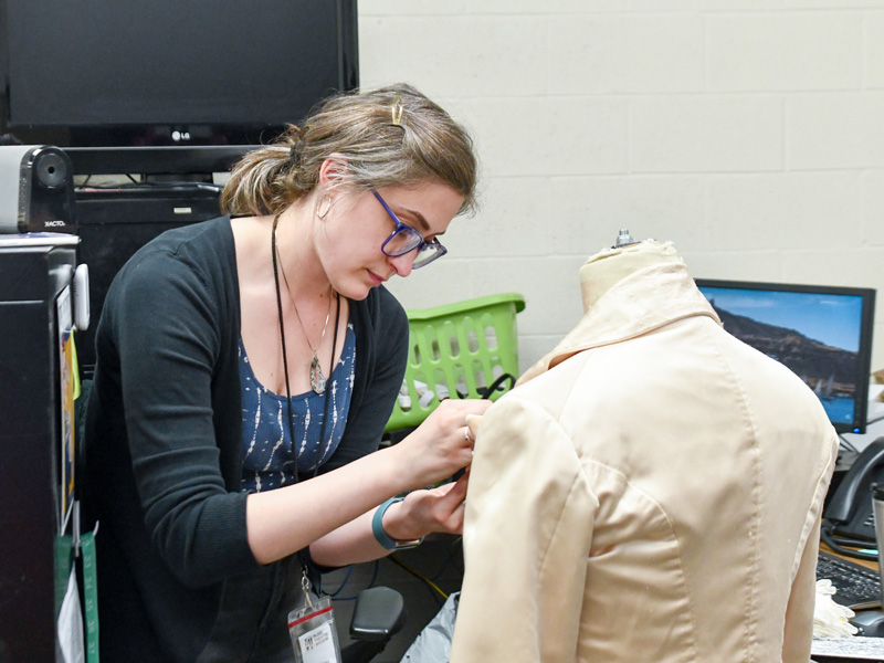 Melissa Penkava Koza works on a costume for a show.