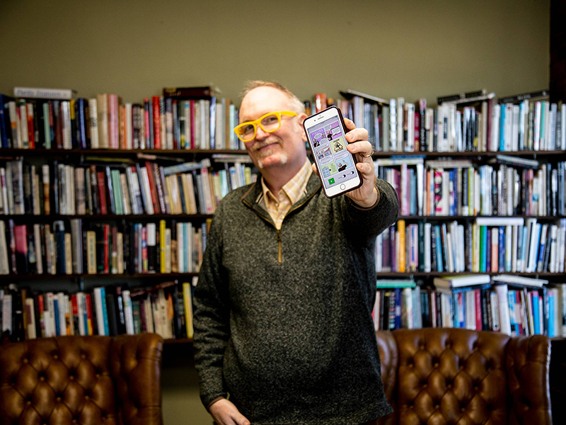 Dr. Darren DeFrain holds a phone that shows the Vizling app he created. 