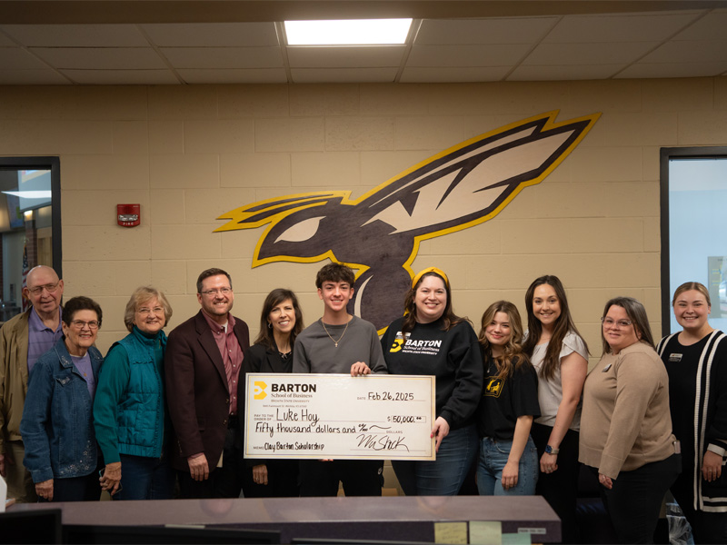 Luke Hoy poses with members of the Barton School and his ceremonial check