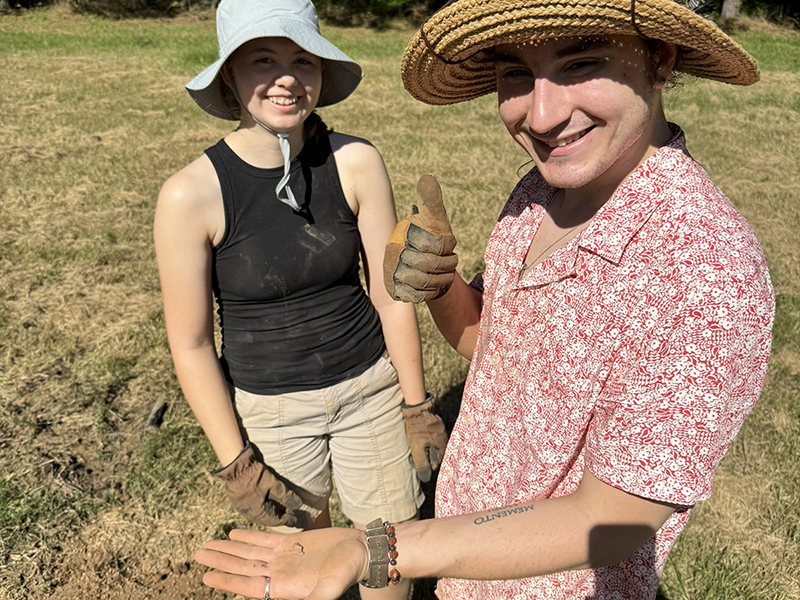 Two students hold out an artifact from an archeology dig in Texas