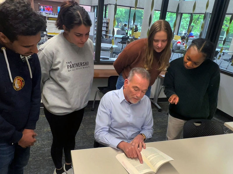 Michael Birzer works with several students in the UReCA office. 