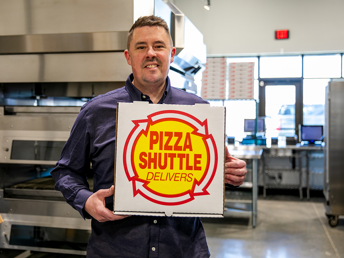Justin Neel holds a Pizza Shuttle box.