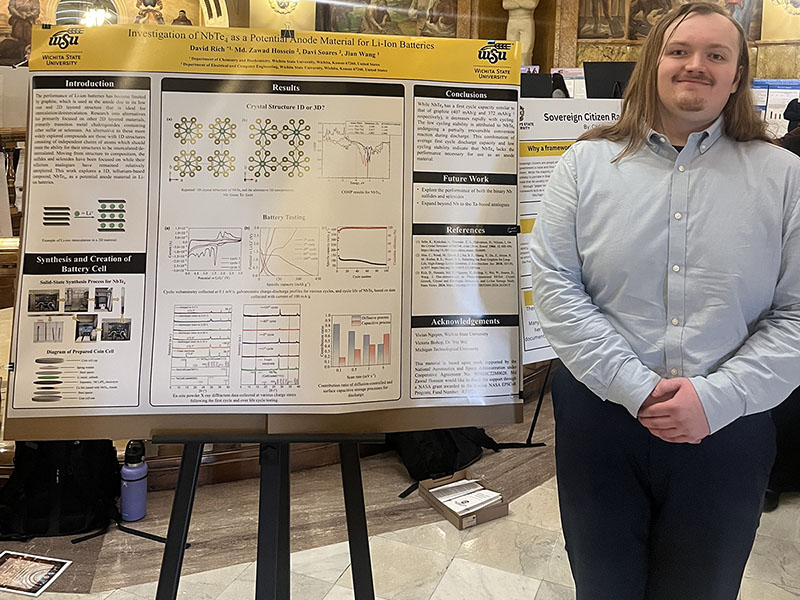 David Rich poses in front of his research poster at the Kansas state capitol