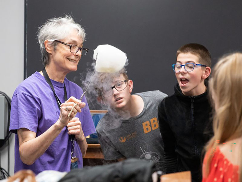 A science teacher does an experiment with middle school students. 