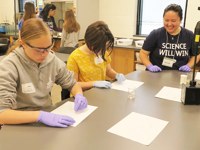 A science teacher does an experiment with middle school students. 