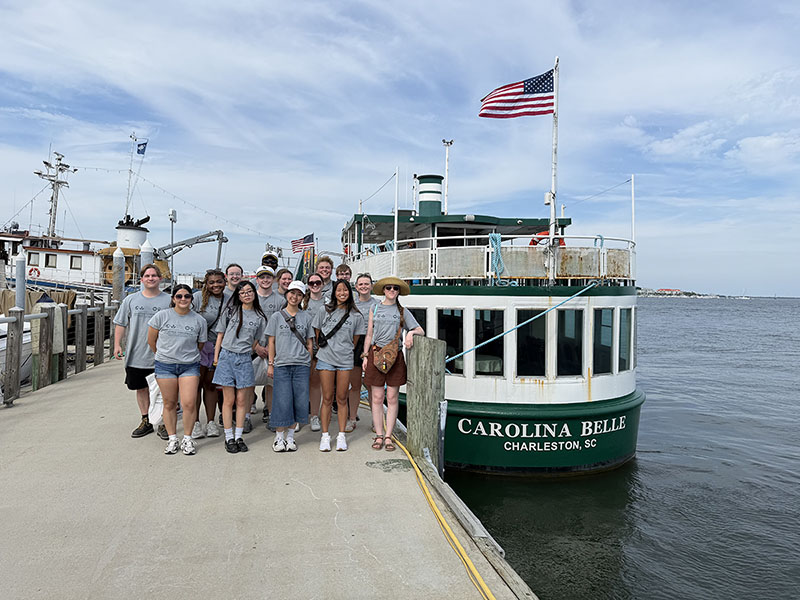 Wichita State students post for a photo near the Carolina Bell ship in Charleston, South Carolina. 