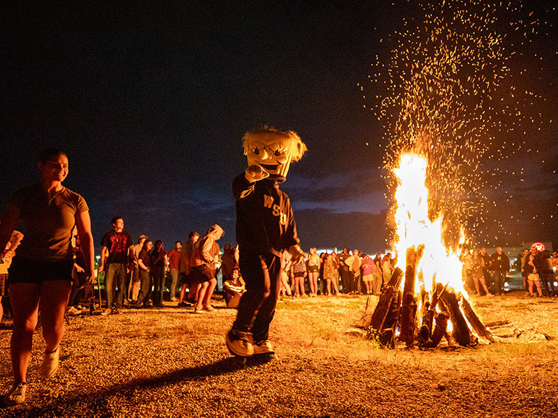 WuShock points at the camera while dancing around a bonfire at Shocktoberfest 2025