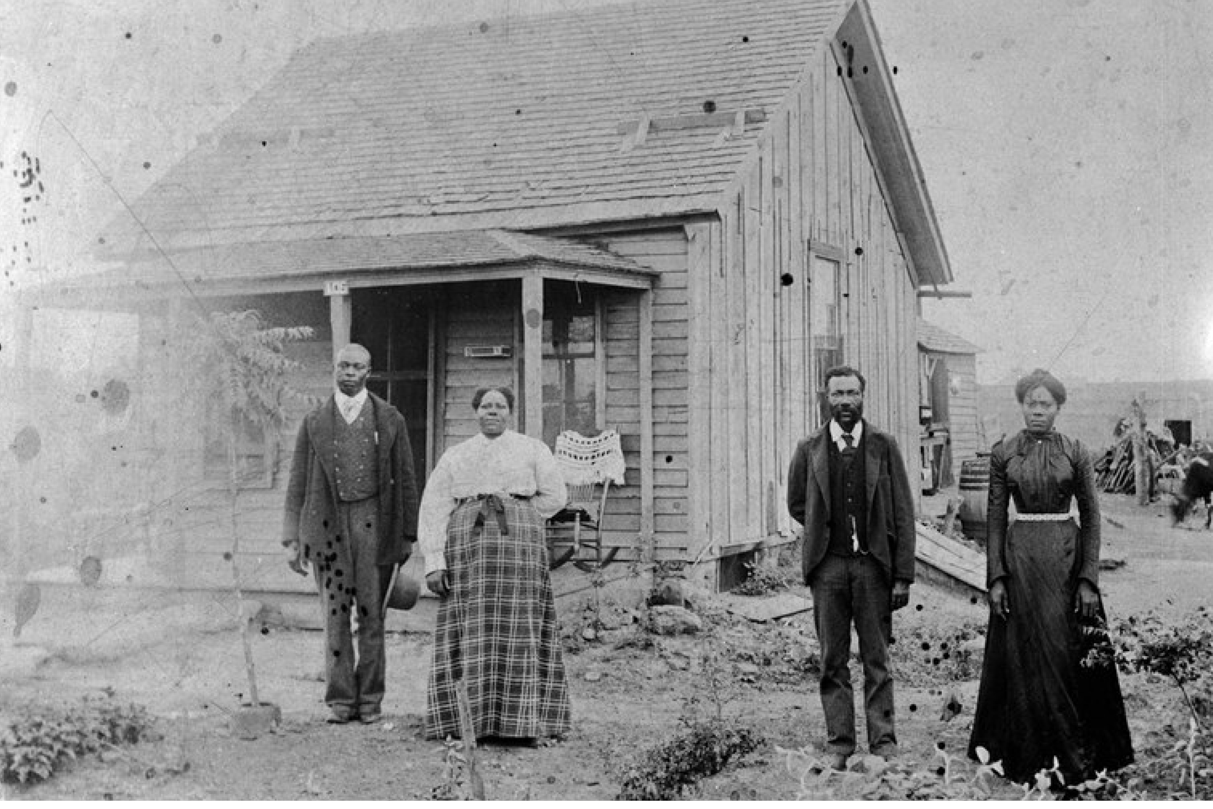 Historic photo of African American settlers in front of a house in Nicodemus, Kansas. Source: High Country News