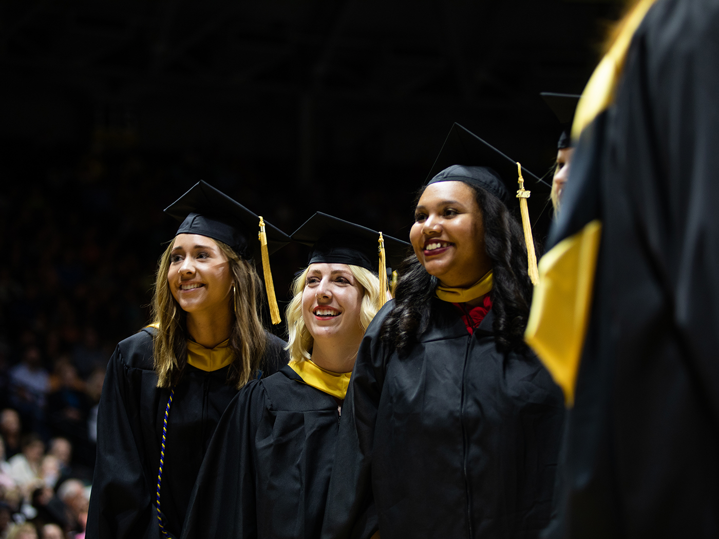 Three graduates in robes and mortar boards