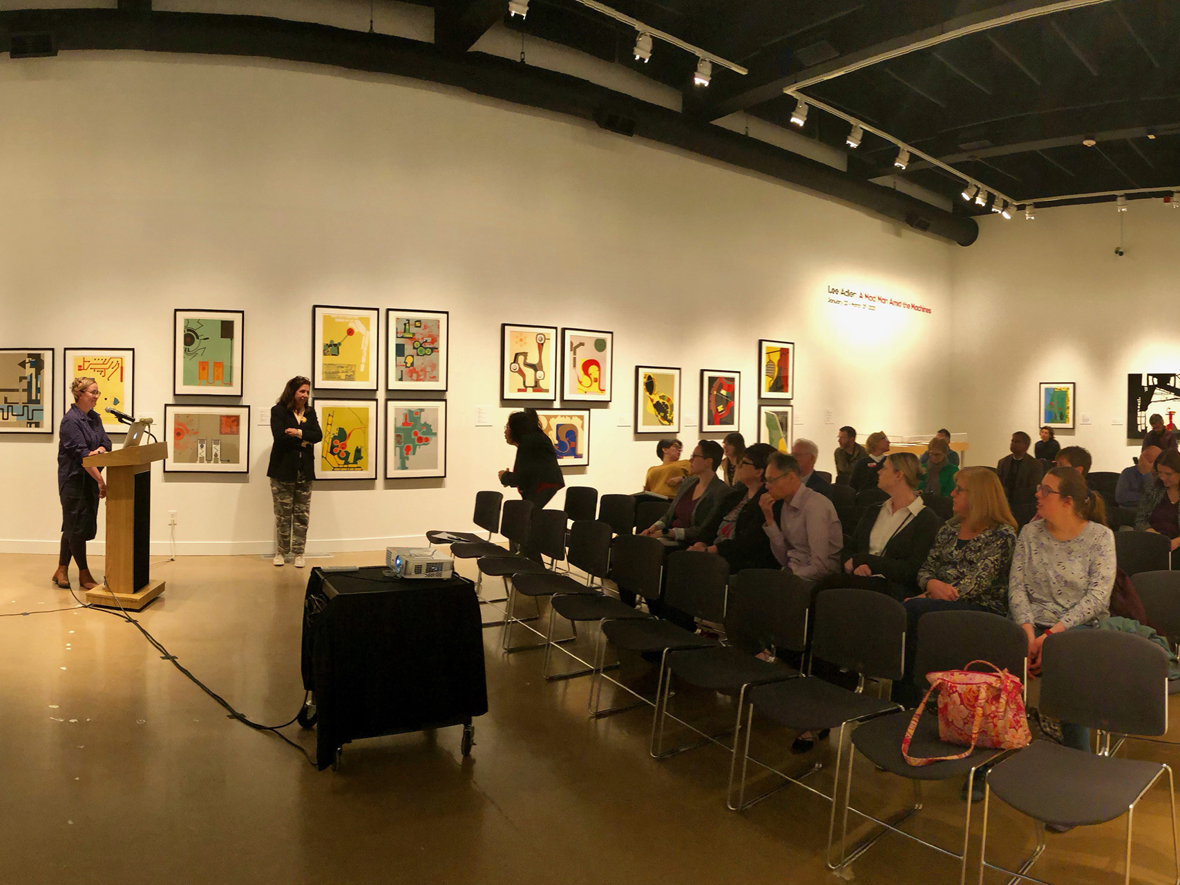 Photo of an audience gathered watching a presentation being put on by a member of the Research Team. 