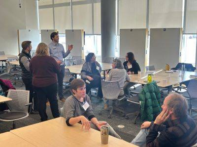 Faculty sit around informally talking at tables following a Faculty Exchange event.