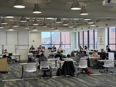 Faculty are sitting at desks typing on their computers at the FARE Faculty Writing Sprint
