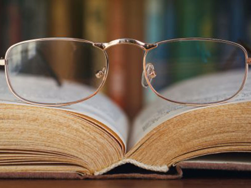 a pair of glasses sitting on top of a book