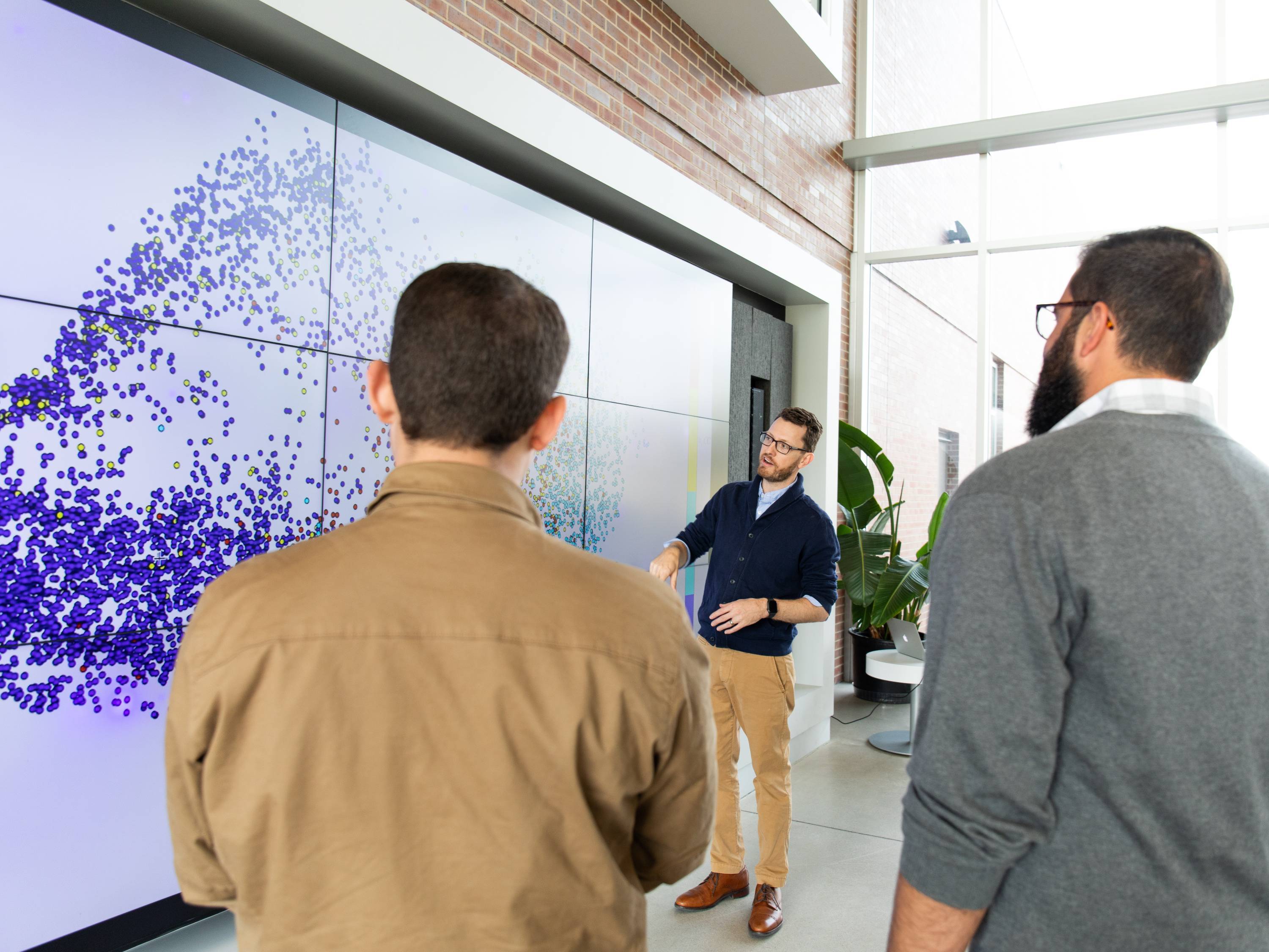 Photo of Professor Mathew Muether giving an analytics demonstration to two other people. 