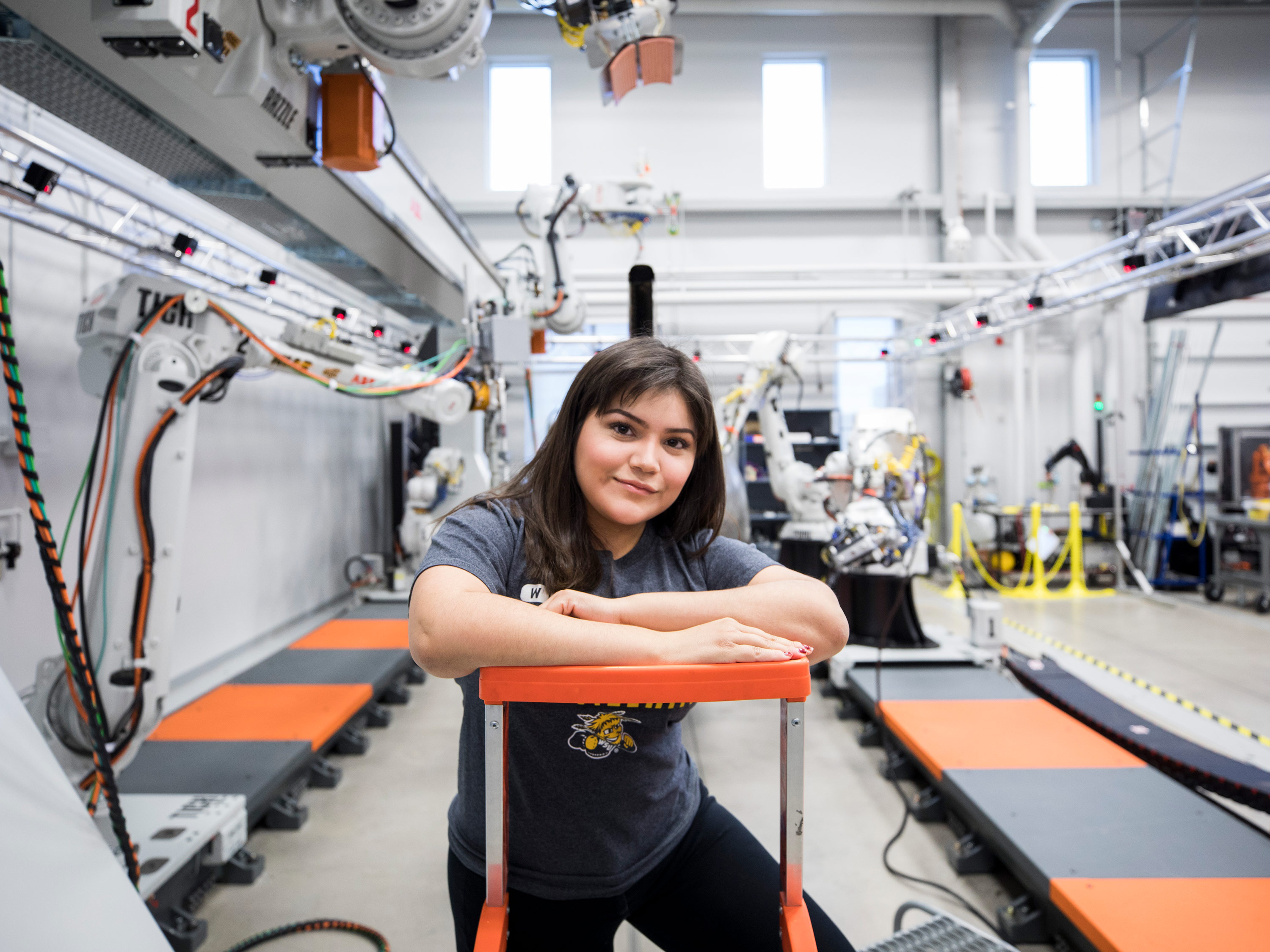 A student poses for a photo in the robotics lab at Wichita State.