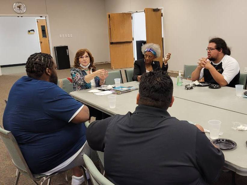 Students and mentors sit at a table for dinner and dialogue