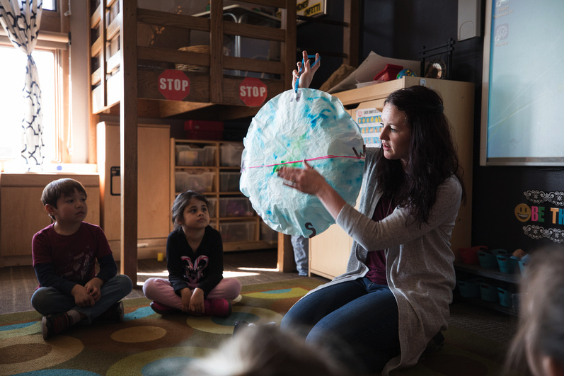 Teacher showing compass to her class