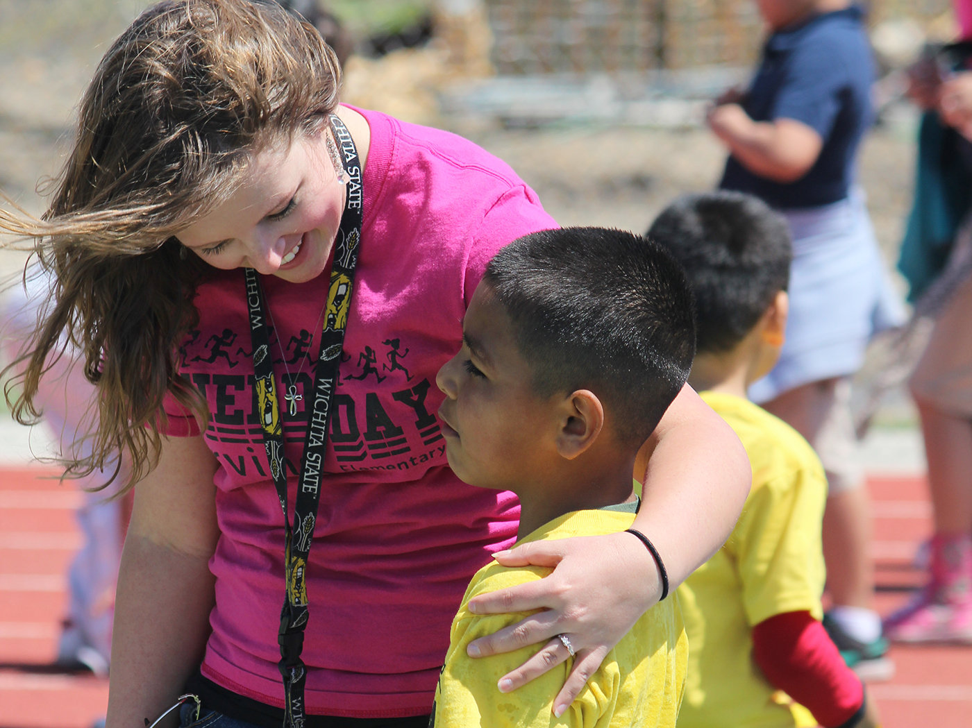 Student teacher giving gradeschooler a hug.