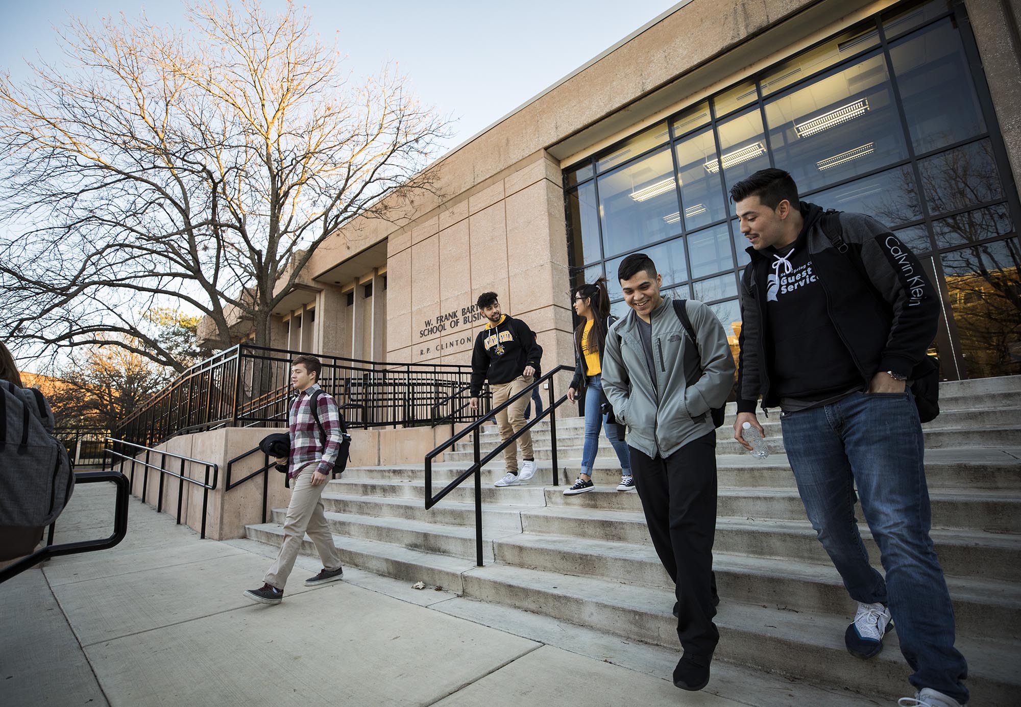 A number of students walking down the steps of Barton School of Business. 