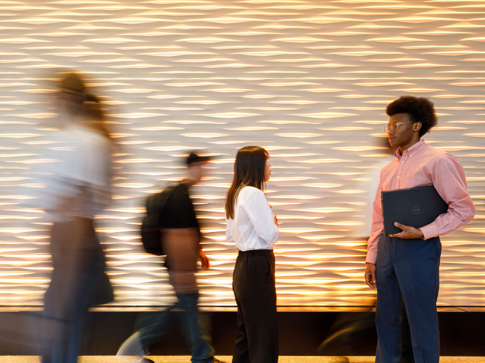 Photo of students walking through Woolsey hall with some blurred
