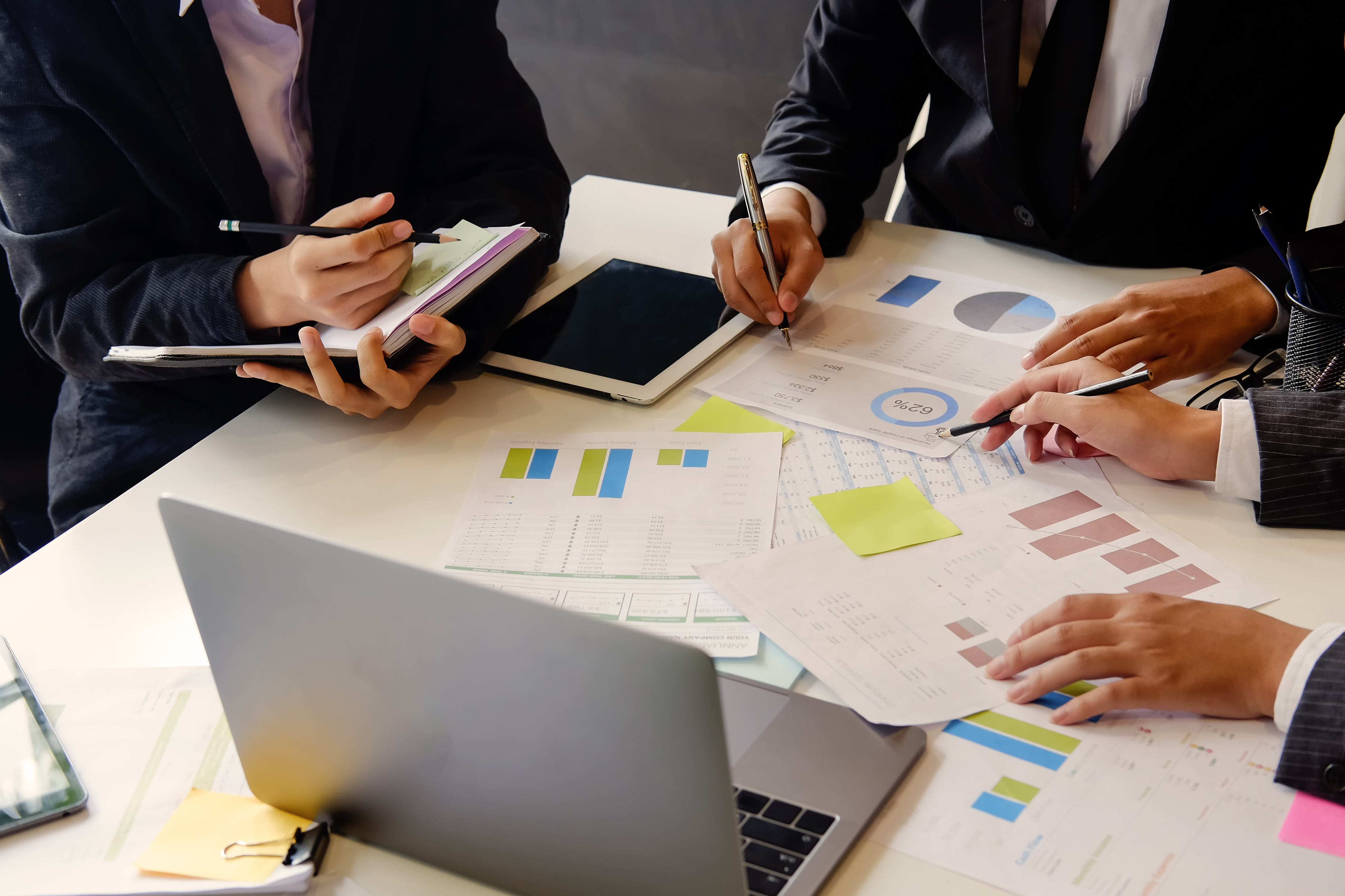 Working professionals gather at a desk to review data