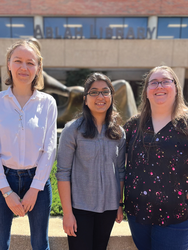 Brittany Wojciechowski, Amulya Lomte, and Maria Jose Carrillo Munoz posed together in front of Ablah Library.