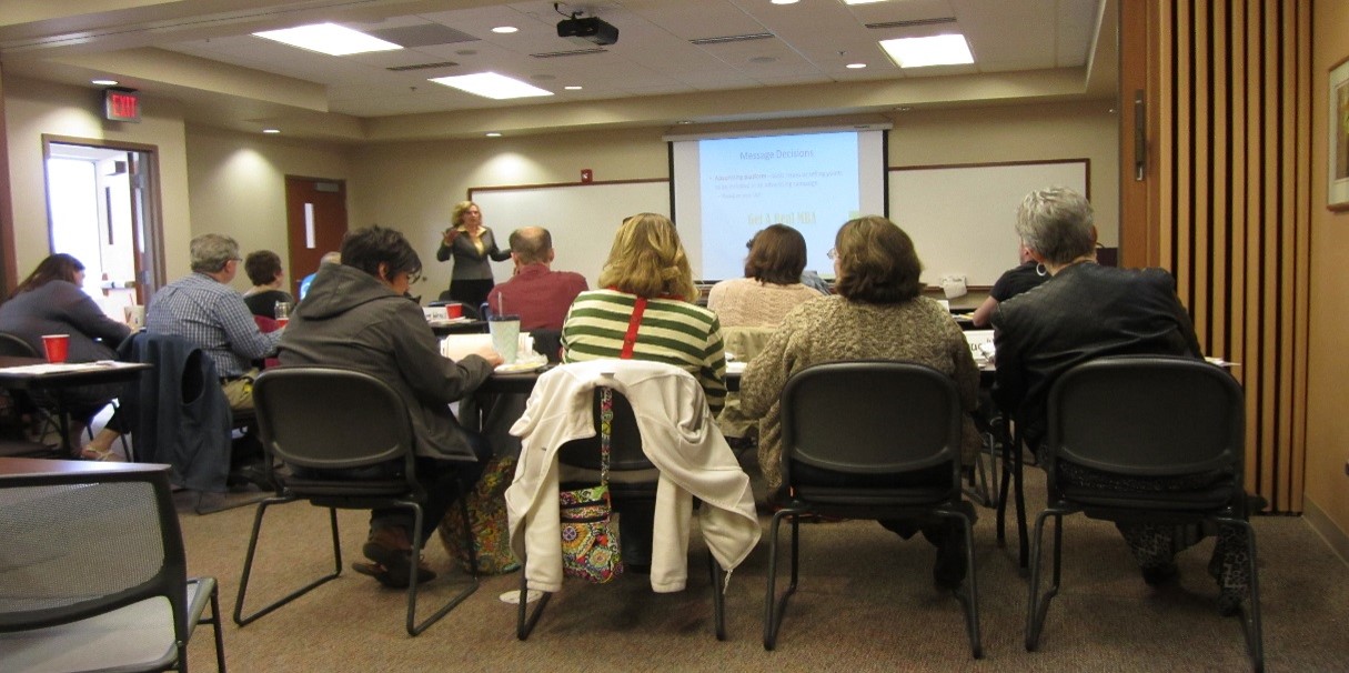 Participants of the Spring 2015 Growing Rural Business Training sitting facing away from the camera listening to the trainer.